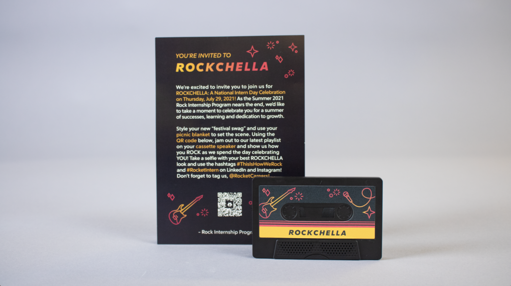 photo of the cassette tape out of it's plastic casing, with a guitar and microphone and the word "rockchella" on it. Behind it is a postcard that contains the same illustrations and the headline "you're invited to rockchella" accompanied by body copy that explains the event.