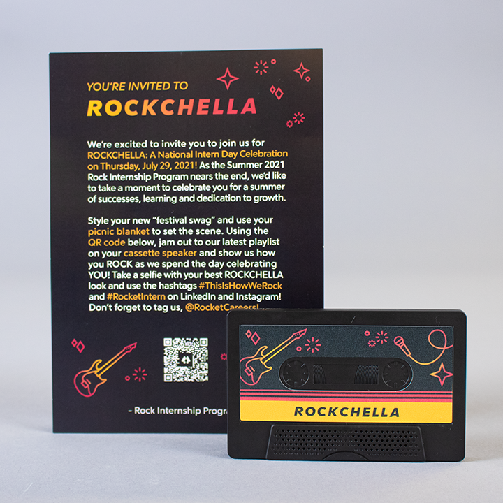 photo of the cassette tape out of it's plastic casing, with a guitar and microphone and the word "rockchella" on it. Behind it is a postcard that contains the same illustrations and the headline "you're invited to rockchella" accompanied by body copy that explains the event.