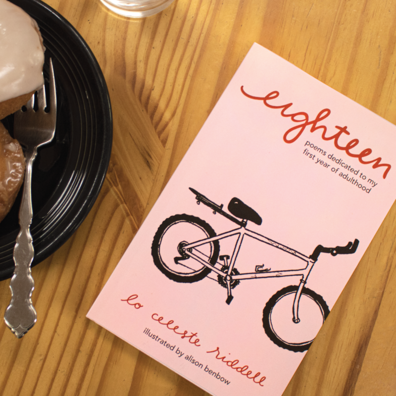 photo of the cover of eighteen sitting on a wooden table with a plate next to it