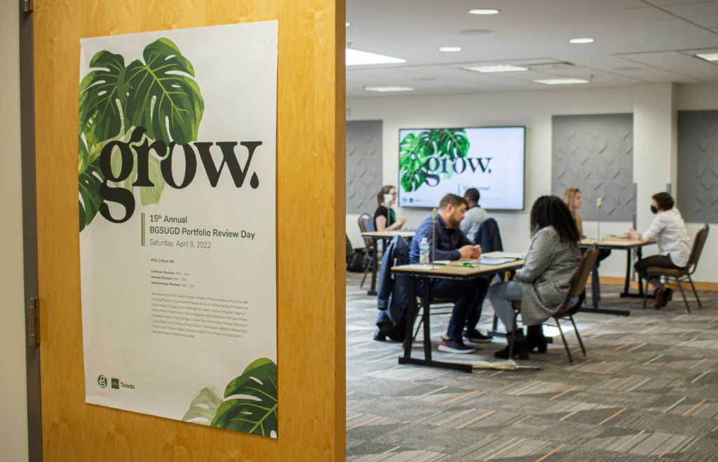 light grow poster in the foreground, with reviewers and students engages in conversation in the background