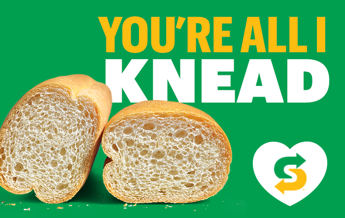 Green gift card with a sliced baguette next to the text "YOU'RE ALL I KNEAD" and the subway choicemark inside of a white heart.
