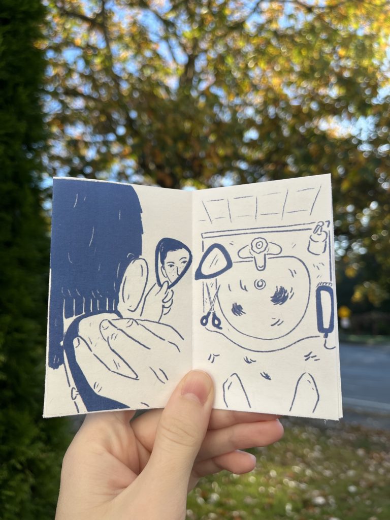 Photos of an 8 page zine held up against a blurry outdoor background. Drawings are in dark blue on a white background. Panel 4: View of the back of the person’s head as they bring the clippers up to their hair and hold a hand mirror out to see what they’re doing. Their eyes and nose are reflected in the mirror, looking at the viewer. Panel 5: Overhead shot of a bathroom sink covered in hair clippings, with the clippers, scissors, and mirror placed around it.