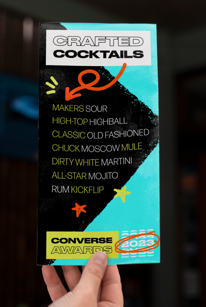 Mockup of a hand holding a "crafted cocktails" sign for the 2023 converse awards.